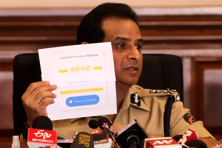 Komisarz policji w Bombaju Hemant Nagrale wyświetla dokument podczas przemawiania na konferencji prasowej.