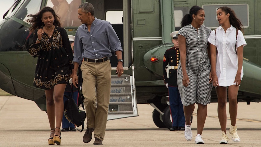 US President Barack Obama, First Lady Michelle Obama and daughters Malia and Sasha walk to board Air Force One.