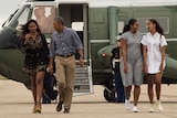 US President Barack Obama, First Lady Michelle Obama and daughters Malia and Sasha walk to board Air Force One.
