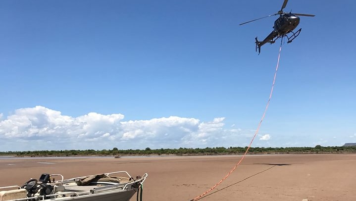 helicopter towing a boat to safety