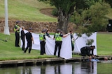 Police divers recover a body from the Torrens