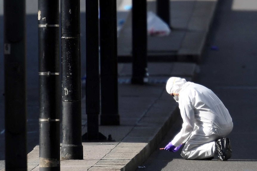 A police forensics investigator wearing a white disposable suit works on London Bridge after the attack.