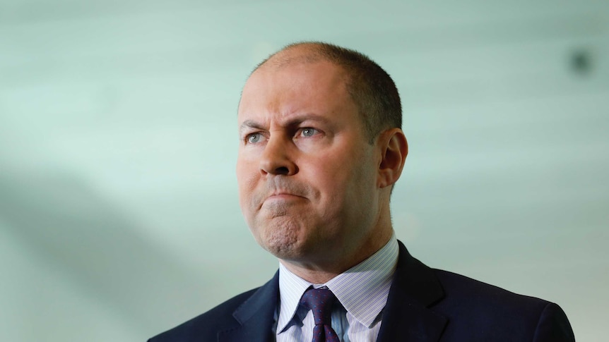 Josh Frydenberg stares intently ahead.