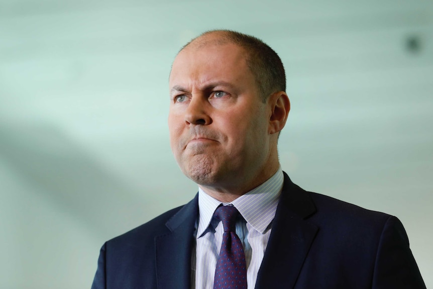 Josh Frydenberg stares intently ahead.