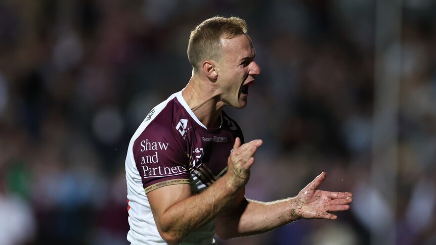 A man celebrates after scoring a try in an NRL match
