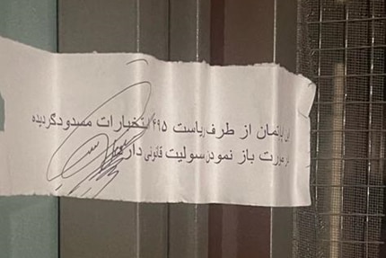 An arabic notice stuck to the door jam of a house, sealing the door frame.