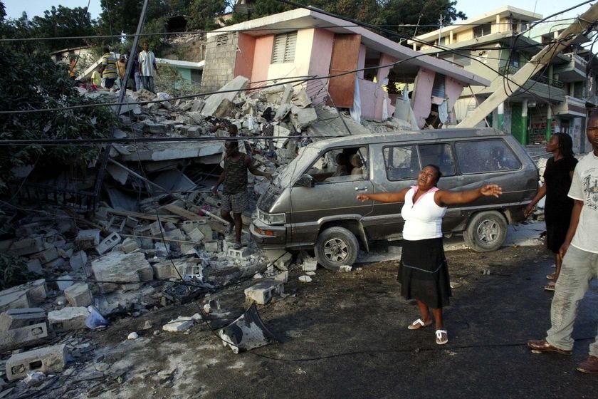 A woman shows her grief near destroyed buildings after an earthquake in Port-au-Prince