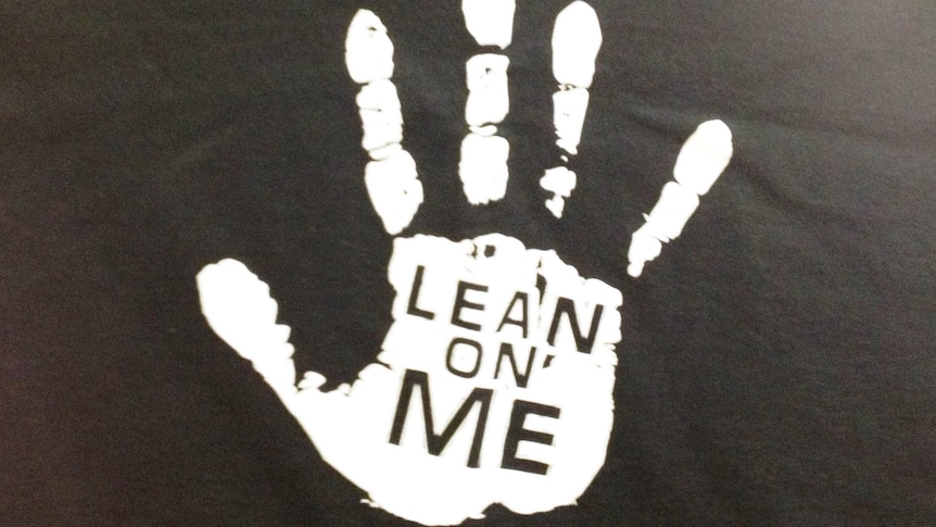 The front of a black t-shirt with a 'lean on me' sign on t-shirt for youth suicide prevention in WA