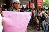 A student belonging to the Muslim community holds a placard at a railway station in Bangalore.