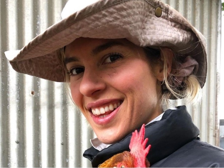 Luen Free holding a chicken on a farm