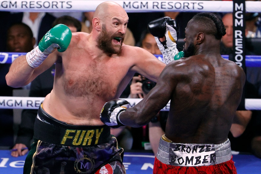 Tyson Fury opens his mouth as he punches Deontay Wilder
