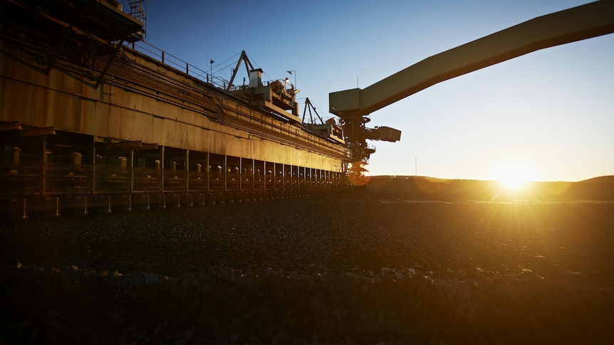 Coal loading infrastructure with the sun setting behind it