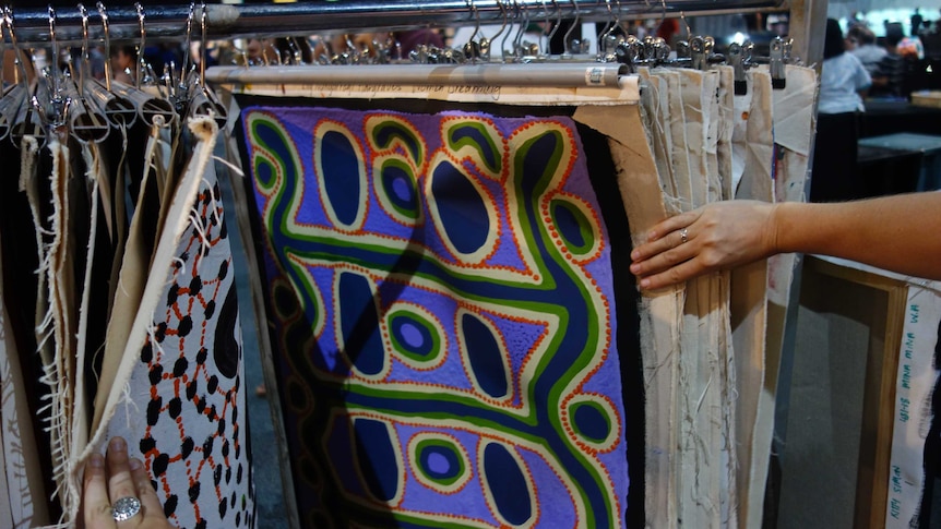 Canvas Aboriginal art hanging on a rack