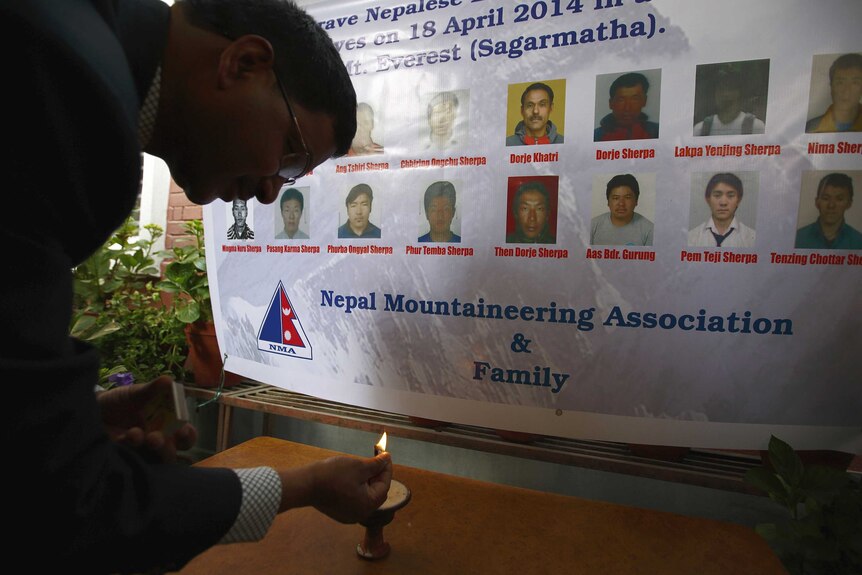 Man lights a candle in memory of Nepal avalanche victims