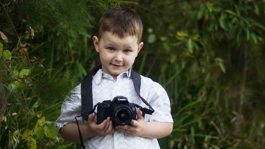 Max, 4, holding a camera in his hands
