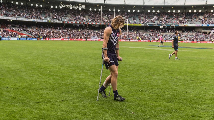 Fremantle's Nat Fyfe leaves the ground on crutches after his team's loss to Carlton