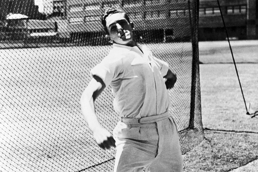 A black and white image of Alan Davidson bowling in the nets in England in 1953.