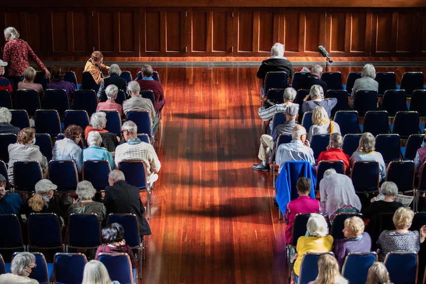 Seats half filled in a hall full of chairs.