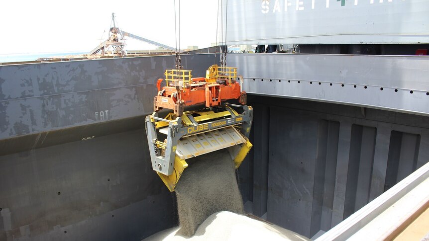 Lithium concentrate being loaded into the hull of a cargo ship.