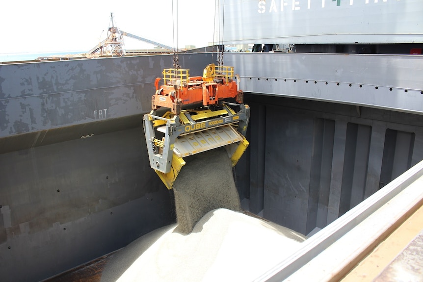 Lithium concentrate being loaded into the hull of a cargo ship.