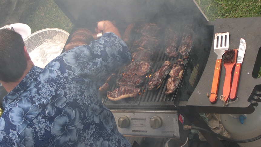 Photo of someone cooking meat and sausages on a barbeque BBQ - good generic