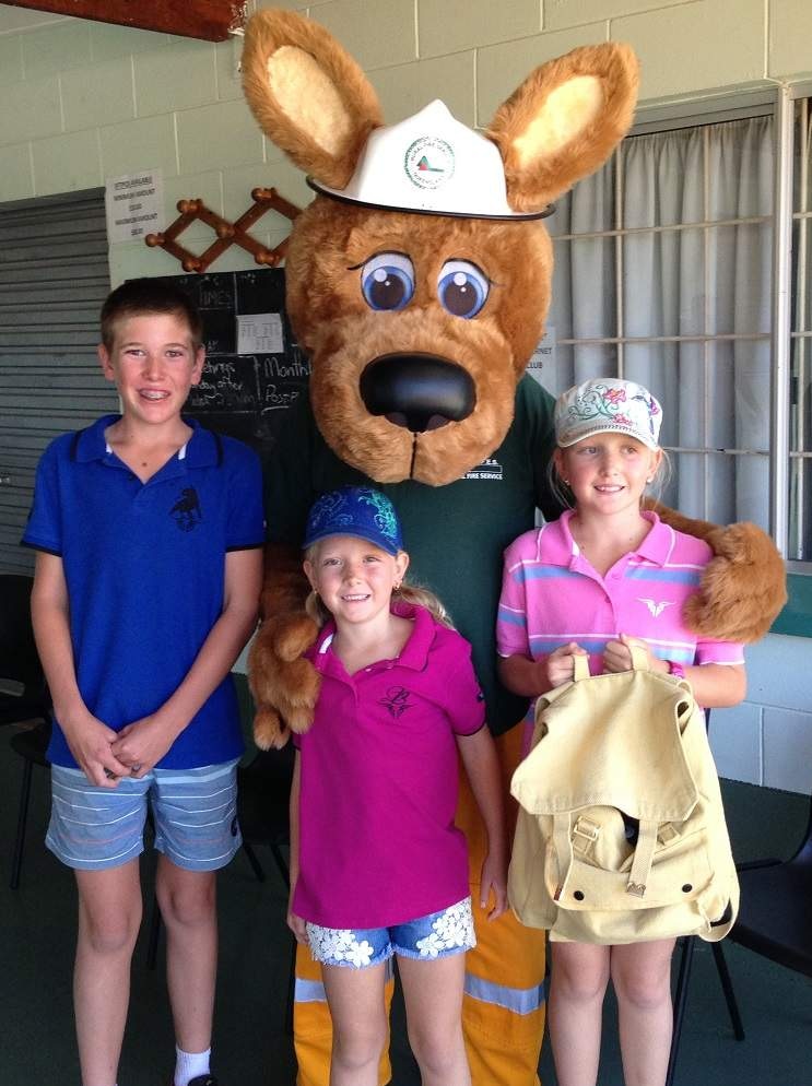 Wallaby mascot wearing a fire hat standing with three children
