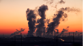 A coal fired power station at sunset with smog rising.