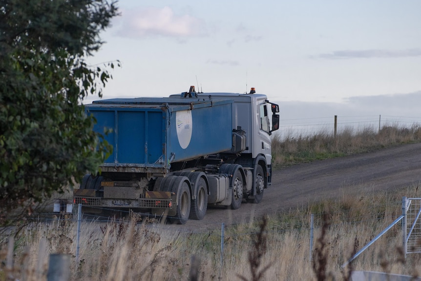A truck driving on a gravel road