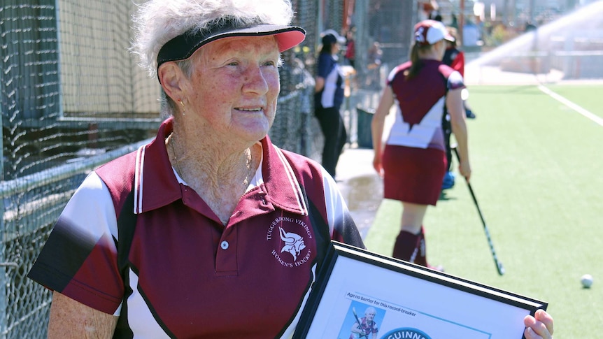 Ms Larsen proudly holds the certificate declaring her the world's oldest competitive female hockey player.