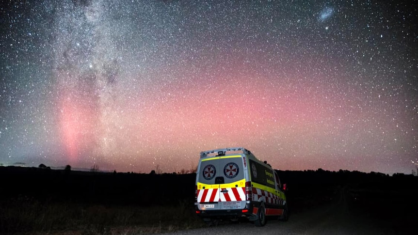 An ambulance vehicle with the aurora australis and stars in the background.