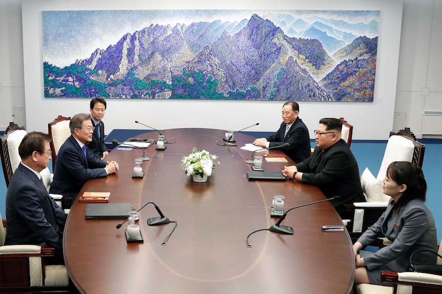 Delegates from the north and south meet over a board room table at the peace house.