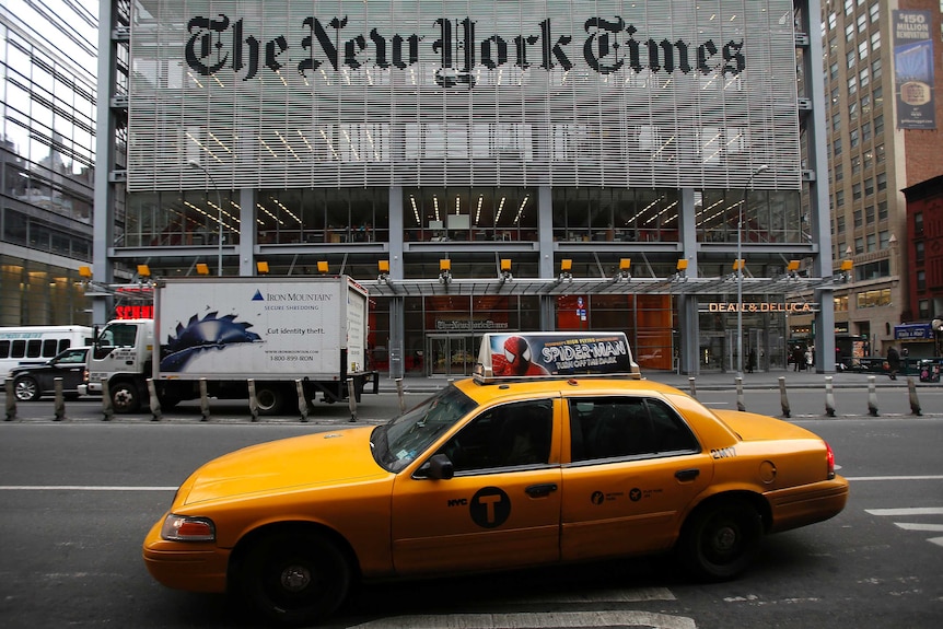 A yellow New York cab sits in front of the New York Times office.