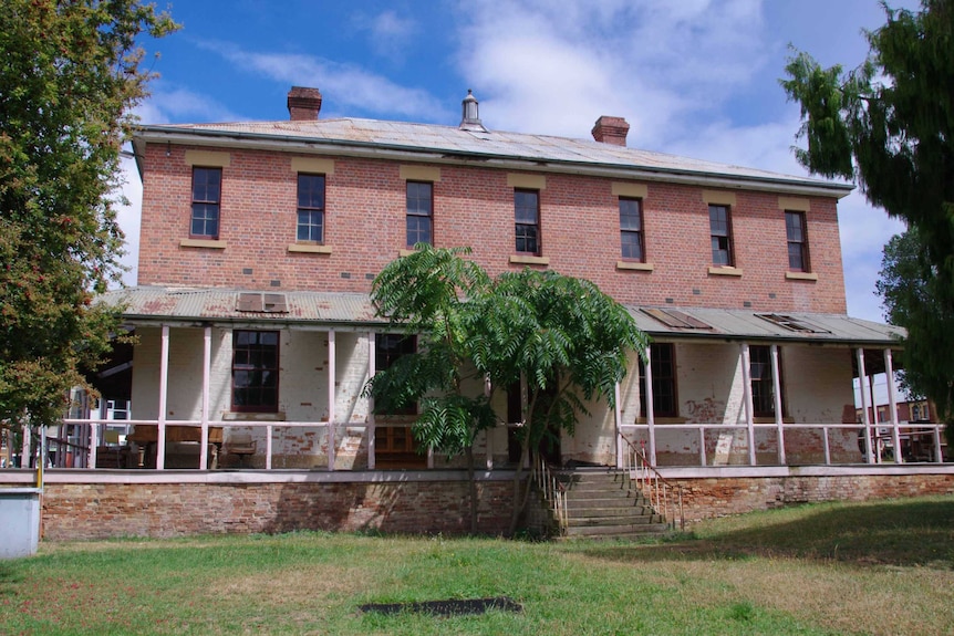 An old double storey brick building with a veranda