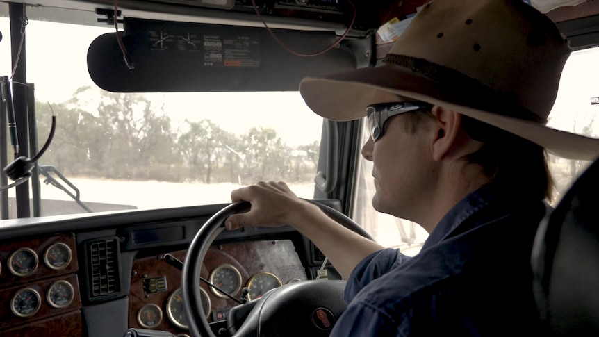 A man wearing a hat driving a truck