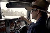 A man wearing a hat driving a truck