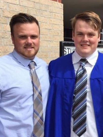 Brenton and Cobin Estorffe smile in the direction of the camera, with Cobin wearing a graduation gown.