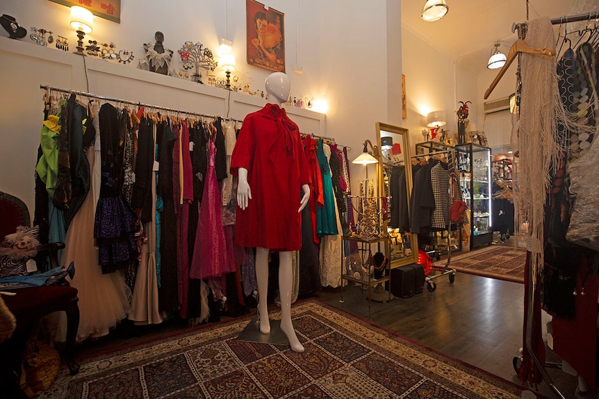 Red silk opera coat hung on a mannequin. Design is by Hall Ludlow.