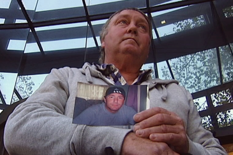 John Caulfield, holding photo of his dead son, Gregory Caulfield