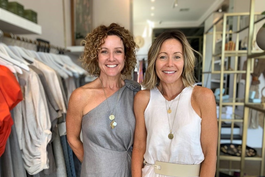 Sam Scally and Penny Duggan smile for the camera in a clothing store.