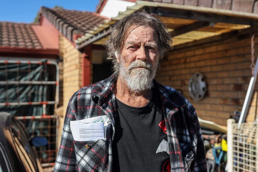 A man standing outside a suburban house