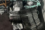 Packages wrapped in plastic and black netting 