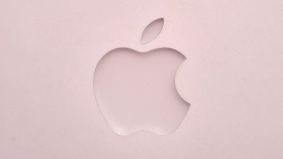 The Apple logo sits on the front of a laptop