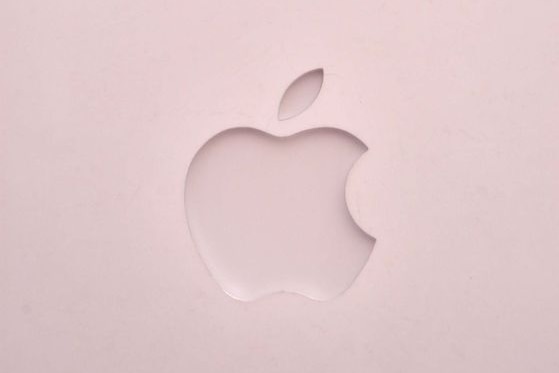 The Apple logo sits on the front of a laptop