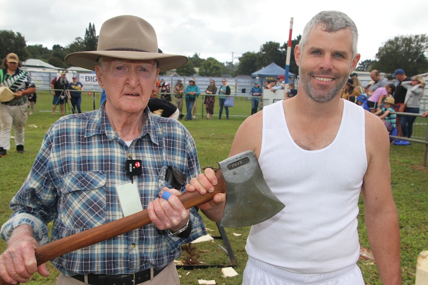 90 year old Martin Conole standing besides Nick Dunell as they both hold an axe 