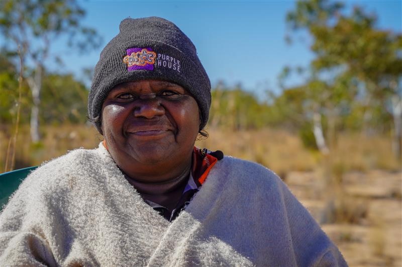 Indigenous woman smiles with beanie on