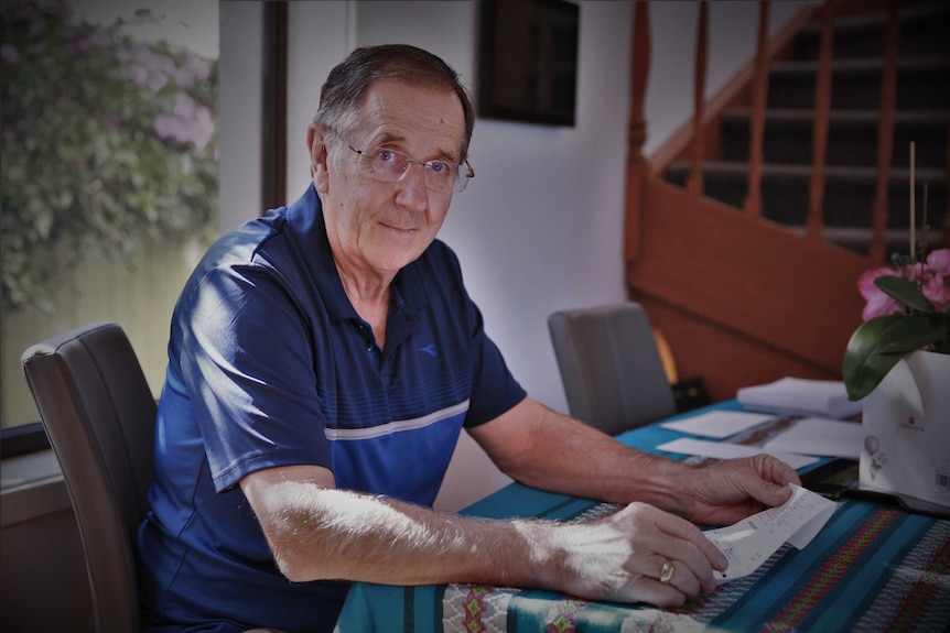 Jim Lloyd sits at a table with a test slip in his hand.