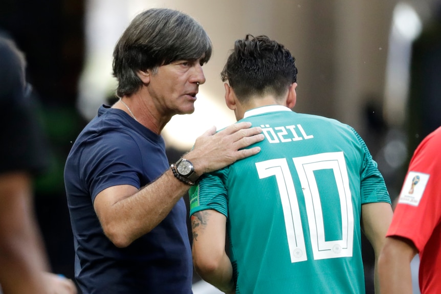 Joachim Loew pats Mesut Ozil on the back