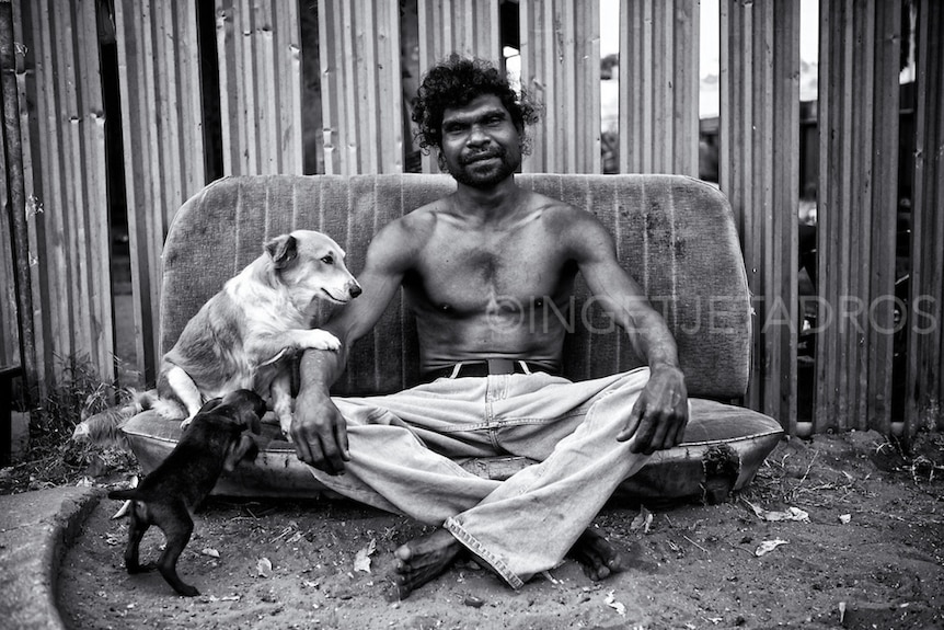 'Billy' Stuart Ah Choo sitting outside his home in Kennedy Hill with his beloved dog Dontee and her pup Little Blacky.