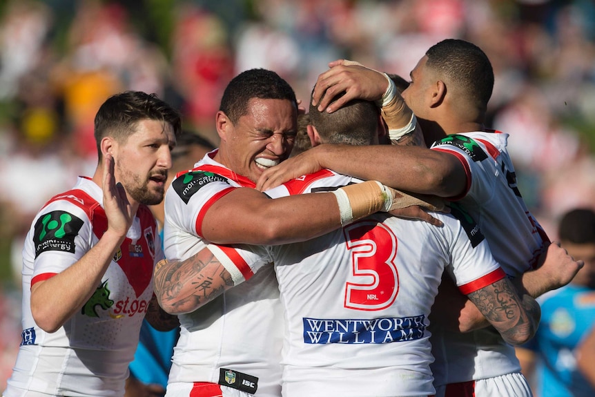 Five Dragons players embrace as they celebrate a try against Titans.
