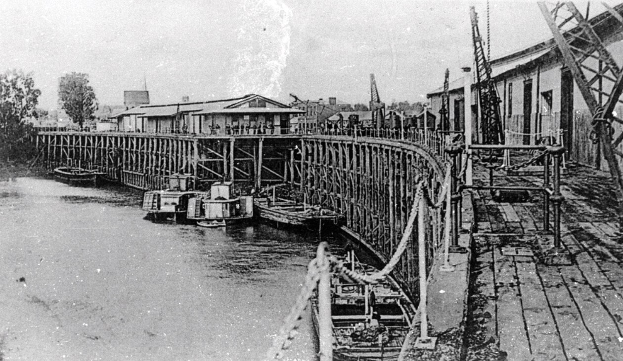 Massive timber wharf with paddle boat